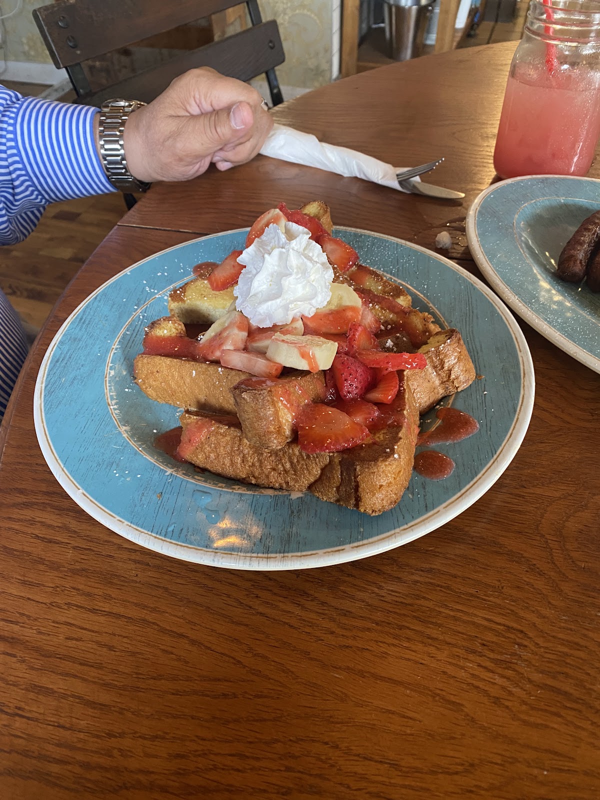 French toast with strawberries and banana on a teal plate