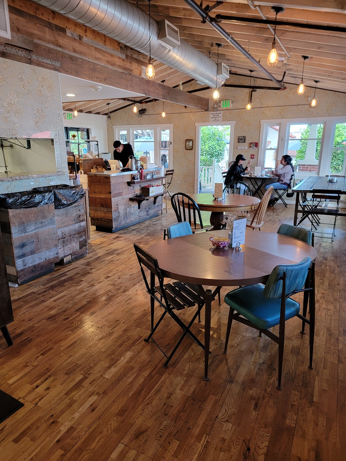 Inside Auntie's, with the reclaimed wood counter, exposed beams and mismatched vintage chairs