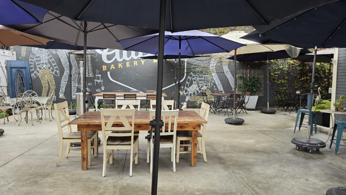 The back patio at Auntie's, with the bakery's logo painted as a mural across the charcoal wall